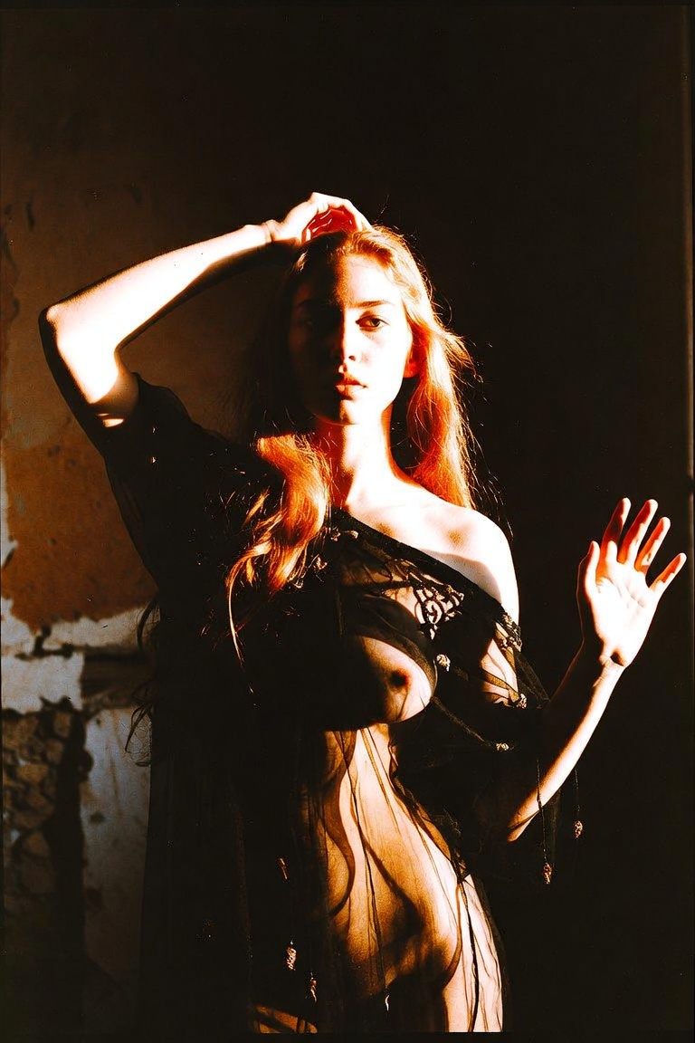 Woman in sheer black fabric, dramatic sunlight