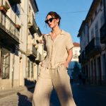 Woman in beige outfit walking European street