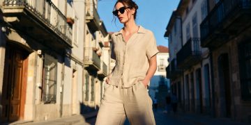 Woman in beige outfit walking European street