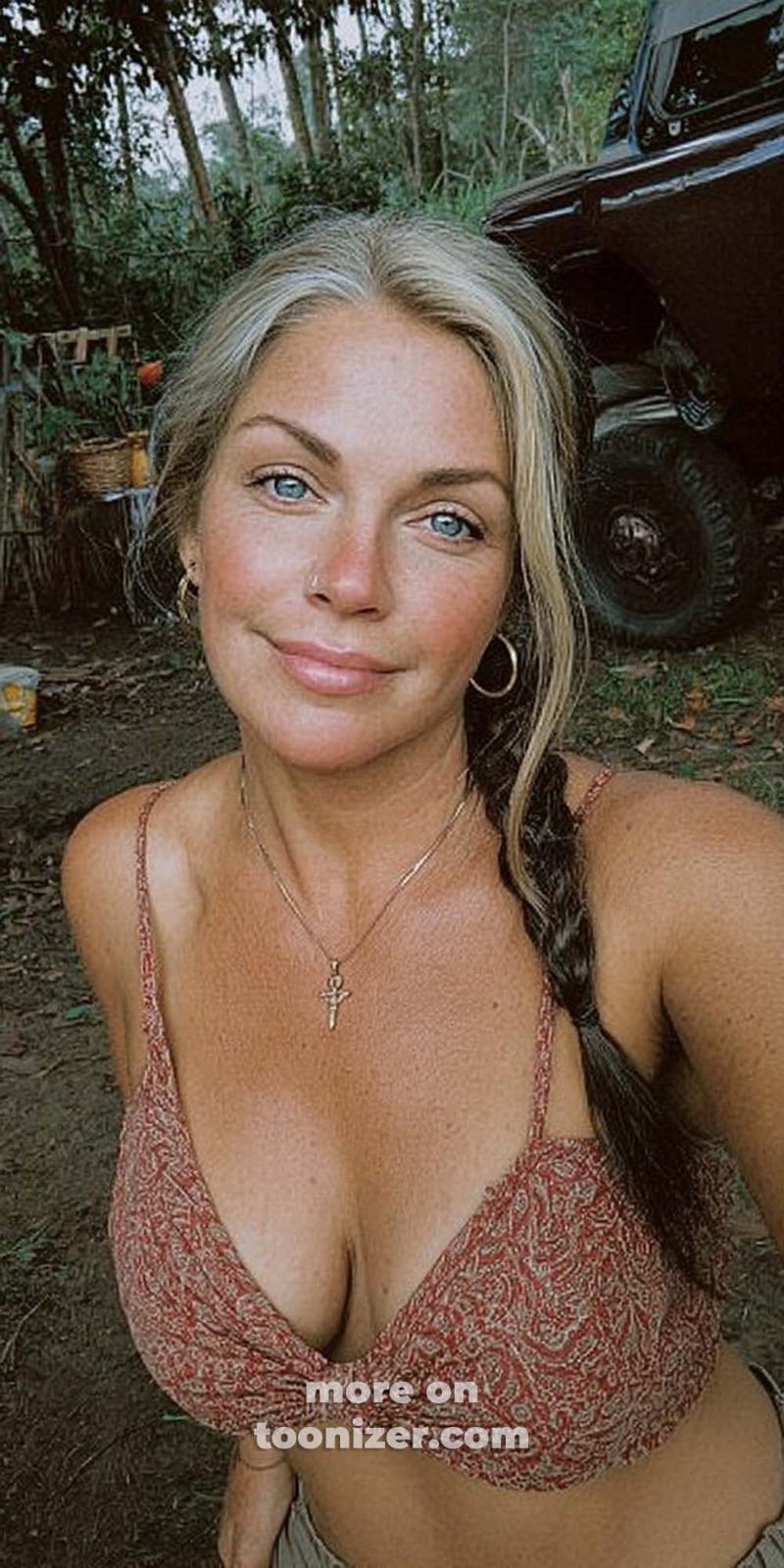 Woman taking outdoor selfie near ATV in woods