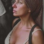 Woman with headscarf and glasses looking outside