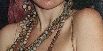 Woman wearing headscarf and layered beaded necklaces